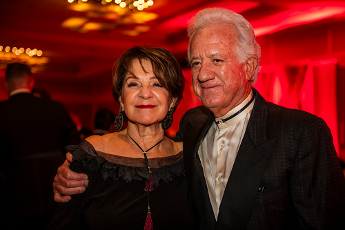 Man standing with his arm around woman next to him.